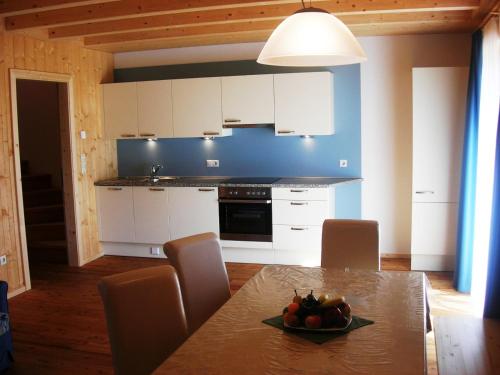 a kitchen with a table with a bowl of fruit on it at Appartments Helvetia in Villabassa