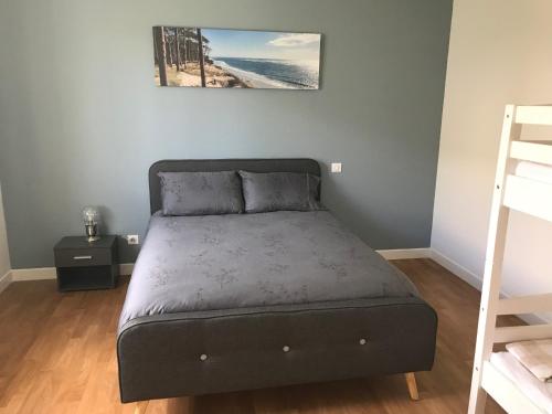 un lit dans une chambre avec un cadre de lit dans l'établissement BISCA MAISON FAMILIALE LANDAISE, à Biscarrosse