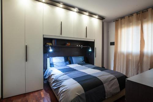 1 dormitorio con 1 cama y armarios blancos en CaseOspitali - CASA I GIARDINI - bilocale a pochi passi dal San Raffaele, en Vimodrone