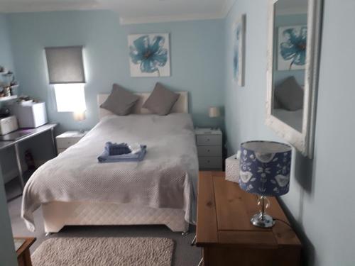 a bedroom with a white bed and a mirror at Santi Bhavana Bed & Breakfast in Westbury