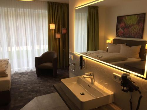 um quarto de hotel com um lavatório e uma cama em Hotel Grünwalde em Halle Westfalen