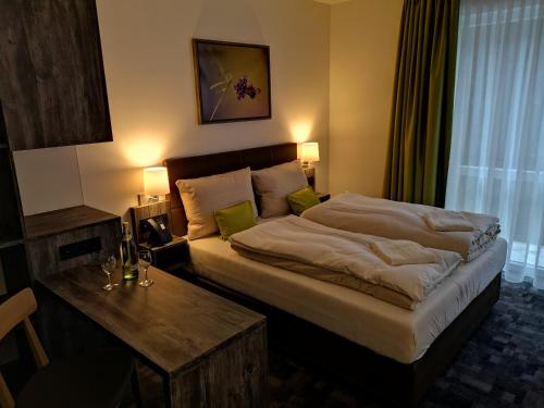 ein Hotelzimmer mit einem großen Bett und einem Tisch in der Unterkunft Hotel Grünwalde in Halle Westfalen