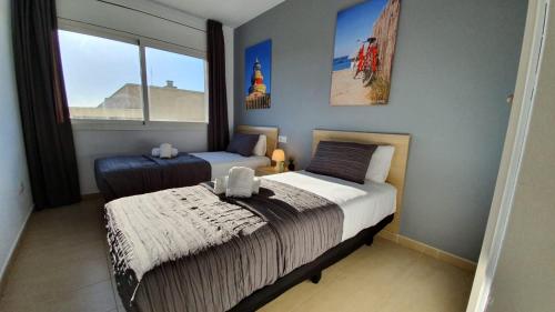 een slaapkamer met twee bedden en een raam bij Salou Med Apartamentos in Salou