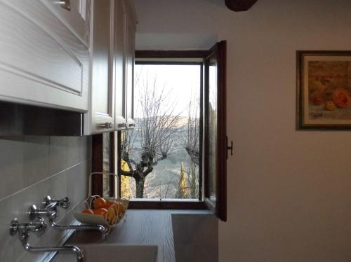 una cucina con finestra e lavandino con vista di CASA SERENA a Montepulciano