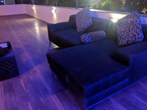 a blue couch sitting on top of a wooden floor at Ivy Orchids Villa - Lonavala in Lonavala