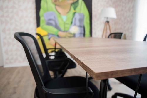 einem Holztisch mit einem schwarzen Stuhl neben einem Tisch in der Unterkunft Gaurez in Buenos Aires