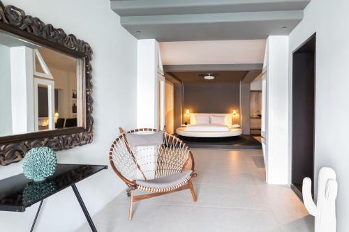 a room with a mirror and a chair and a bed at Kivotos Mykonos in Ornos
