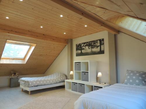 a attic bedroom with two beds and a window at Gîte ESPERANZA SPA et SAUNA in Hazelbourg