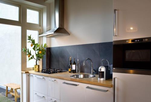 a kitchen with a white counter top and white cabinets at Haarlem Hotel Suites in Haarlem