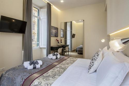 ローマにあるクィリティ バチカン ルレのベッドルーム1室(大型ベッド1台、壁掛けテレビ付)