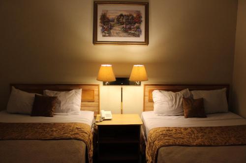 two beds in a hotel room with two lamps at Hotel Mediterraneo Plaza in San Salvador