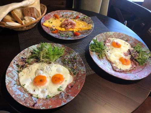four plates of food on a table with eggs at Fiáker Panzió in Zalaszentgrót