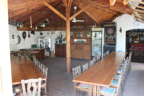 comedor grande con mesas y sillas de madera en Mandel Camping, en Paloznak