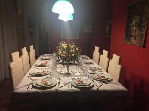 a table with plates and glasses and a vase of flowers at RESIDENZA D'ORIA B&B in Foggia