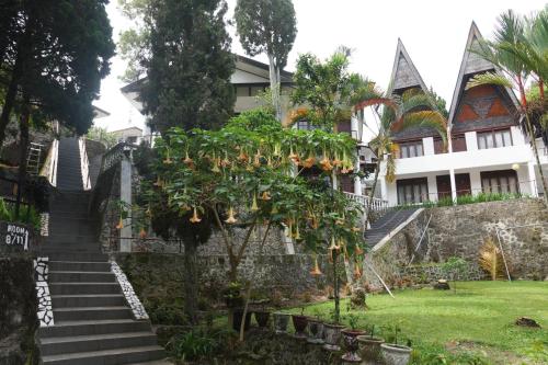 a building with stairs and a tree in front of it at Toledo Inn in Tuk Tuk