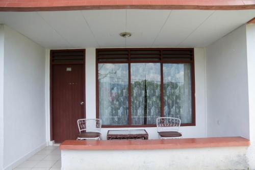 two chairs and a table in front of a window at Toledo Inn in Tuk Tuk