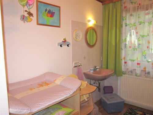 a childs bathroom with a crib and a sink at Appartement am Hauser Kaibling in Haus im Ennstal