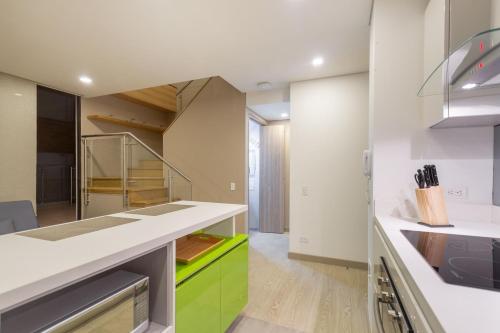 a kitchen with white counters and green cabinets at Apartametos FACILE in Bogotá