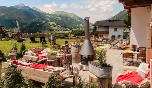 a patio with furniture and mountains in the background at Hotel zum Urviech -Erwachsenenhotel- in Ehrwald