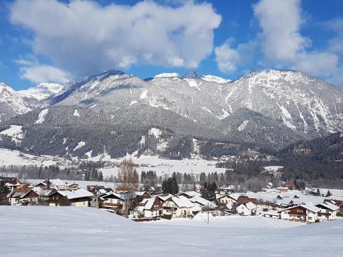 a village in the snow with mountains in the background at Appartement am Hauser Kaibling in Haus im Ennstal