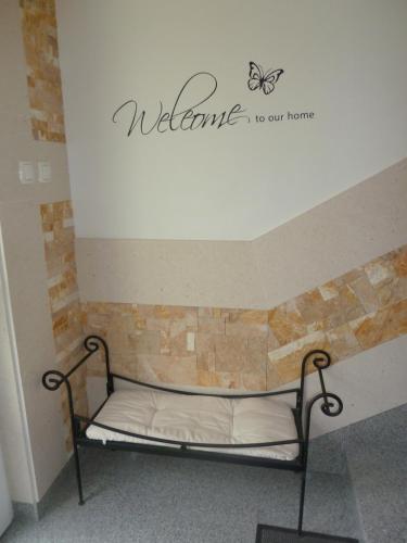a bed in a room with a sign that reads welcome to our home at Apartments Aurora in Zadar