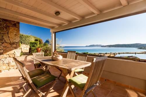 a table and chairs on a patio with a view of the water at Molarotto in Porto Taverna