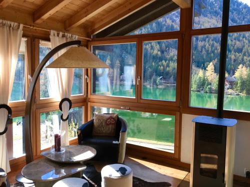 a room with a large window with a chair and a table at Chalet au Paradis with great views, hot tub, sauna & garden in Champex