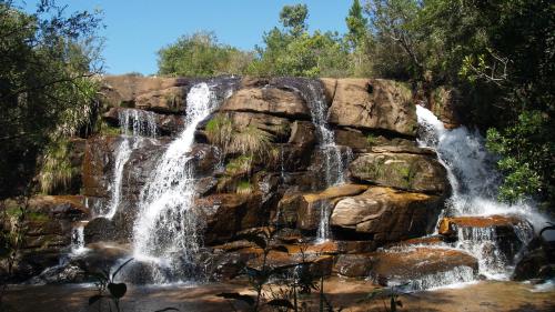 a waterfall on the side of a rock wall at Hotel Fazenda Itáytyba in Tibagi