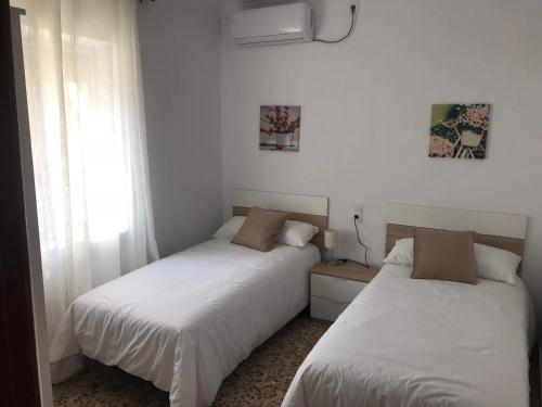 two beds sitting next to each other in a bedroom at Casa patio ribera de córdoba in Córdoba