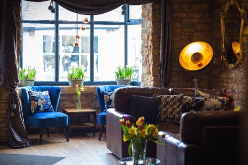 a living room with couches and tables and windows at Chester House Hotel in Bourton on the Water