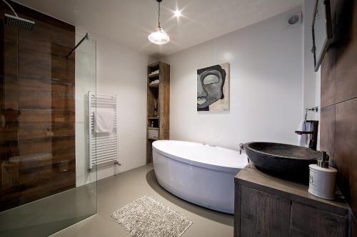 ein Badezimmer mit einer großen Badewanne und einem Waschbecken in der Unterkunft Villa BBB in Oosterhout