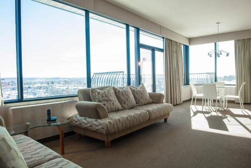 a living room with a couch and large windows at Hôtel Castel in Granby