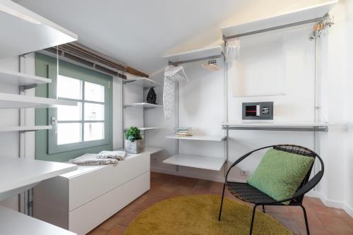 une cuisine avec des placards blancs, une chaise et une fenêtre dans l'établissement Le Château - THE MOST BEAUTIFUL SIGHT IN OLD TOWN, private terrace, à Nice