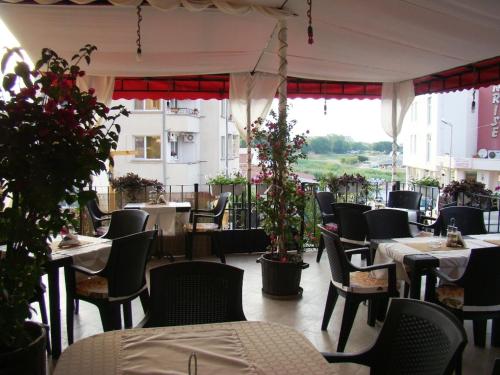 a restaurant with tables and chairs and flowers on a patio at Hotel Bellisimo in Lozenets