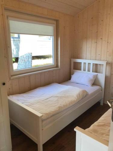 a white bed in a room with a window at Park Wodny Cieszyno in Połczyn-Zdrój