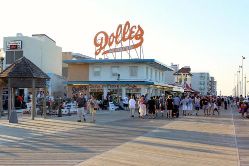 a group of people walking on a boardwalk at Oceanus Motel - Rehoboth Beach in Rehoboth Beach
