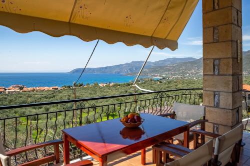 a table on a balcony with a bowl of fruit on it at Papanestoras Apartments in Kardamili
