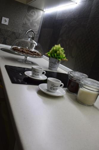 una encimera de cocina con 2 tazas de café y una planta en Apartman Bloom, en Bar