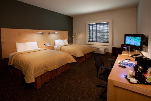 a hotel room with two beds and a desk at Hotel Artesia in Artesia