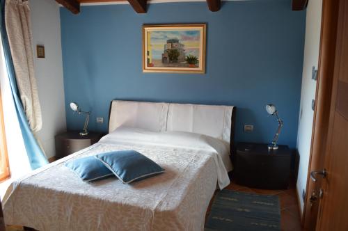 a bedroom with a bed with a blue wall at La Corte Di Langa in Albaretto Della Torre 
