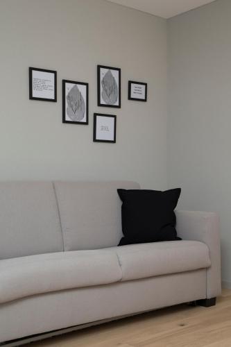a couch in a living room with pictures on the wall at Businesshotel Forum Widnau in Widnau