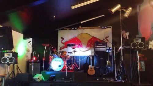 a stage with a band on it in a room at Railway Hotel Greymouth in Greymouth
