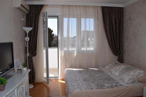 a bedroom with a bed and a sliding glass door at Apartman Bloom in Bar