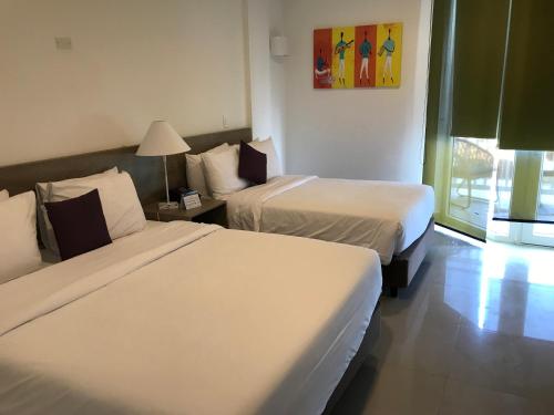 a hotel room with two beds and a window at Hotel Decameron Maryland All Inclusive in San Andrés