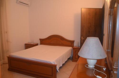 una camera con un letto e una lampada su un tavolo di Villetta Sakapo' a Corigliano dʼOtranto