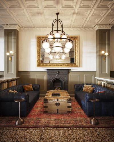 a living room with couches and a chandelier at The Armstrong Hotel in Fort Collins