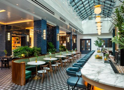 a bar with tables and chairs in a restaurant at Dream Nashville, by Hyatt in Nashville