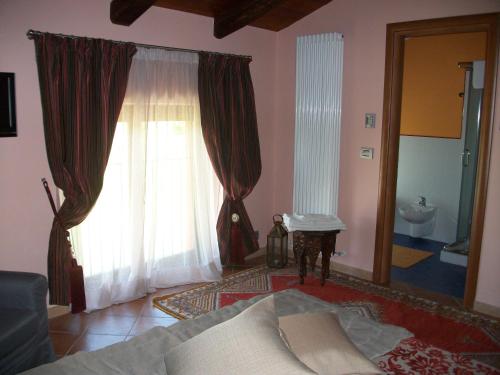 a living room with a couch and a large window at La Corte Di Langa in Albaretto Della Torre 