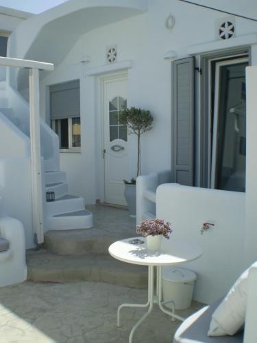 a white room with a white table and stairs at Eleftheria Veloudiou in Tinos Town