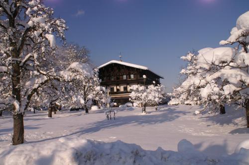 a building covered in snow in front of trees at Alpenhof Landhotel Restaurant in Oberaudorf